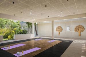 乌代浦Essentia Luxury Resort & Spa Udaipur的瑜伽室,地板上配有紫色垫