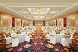 乌代浦Essentia Luxury Resort & Spa Udaipur的摆着白色桌子和椅子的宴会厅 更多37张照片