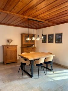 a dining room with a wooden table and chairs at Ferienhaus an der Drau in Sankt Oswald