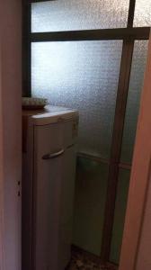 a kitchen with a small refrigerator and a window at Apartamento porta da praia - Ocian in Samaritá +1 photo