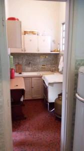 a kitchen with white cabinets and a red floor at Apartamento porta da praia - Ocian in Samaritá
