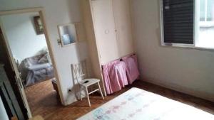 a room with a chair and a window and a mirror at Apartamento porta da praia - Ocian in Samaritá