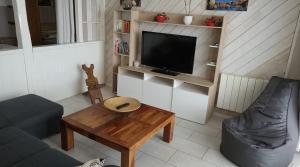 a living room with a couch and a table and a tv at Appartement Vue Mer, RDC, Plage de Trestrignel in Perros-Guirec +6 photos
