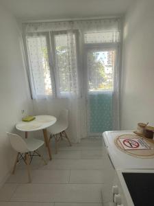 a kitchen with a table and chairs and a window at Apartman Nikka in Bihać