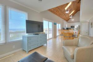 a living room with a flat screen tv and a couch at Dune Alright in Oak Island