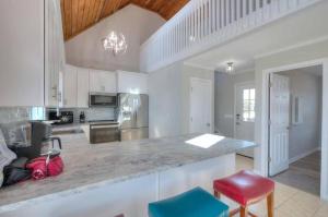 a large kitchen with a counter and chairs in it at Dune Alright in Oak Island