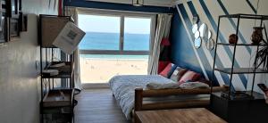 een slaapkamer met een bed en uitzicht op het strand bij Appart n°22, VUE MER, Plage in Perros-Guirec