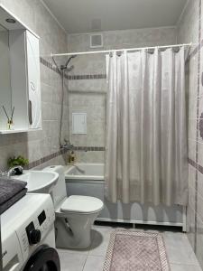 une salle de bain avec toilettes, lavabo et douche dans l'établissement Green Park Однокомнатная, à Aktau