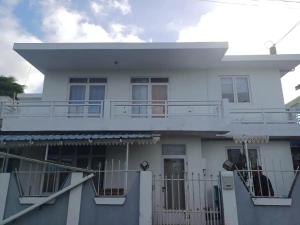 a white house with a balcony and a fence at Appartement avec terasse in Bel Air