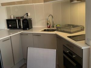 a small kitchen with a sink and a microwave at Estudio la Pineda playa in La Pineda