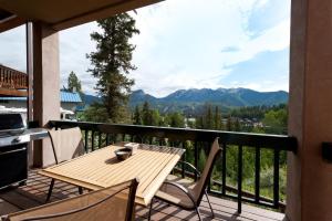 einen Holztisch und Stühle auf einem Balkon mit Bergblick in der Unterkunft 210 Sheol Street in Durango Mountain Resort