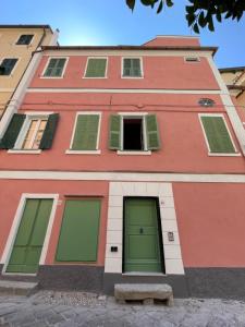 a red building with green doors and windows at Old Town Bonbonniere in Bordighera