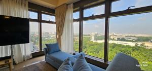 a living room with a blue couch and a large window at Serenity by Zen Residences at The Radiance Manila Bay in Manila