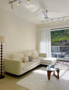 a living room with a white couch and a window at Mizu Homestay Kea Farm 10mins to BOH in Cameron Highlands