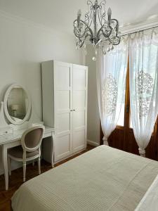 a bedroom with a bed and a desk and a chandelier at Un Nido nel Verde in Cervia +19 photos