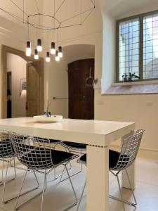 a dining room with a white table and chairs at Antica Foligno - Novellis de coarazze in Foligno