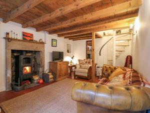 un salon avec un canapé et une cheminée dans l'établissement Rock Cottage, à Ashbourne