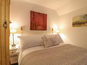 une chambre avec un lit et un tableau au mur dans l'établissement Rock Cottage, à Ashbourne