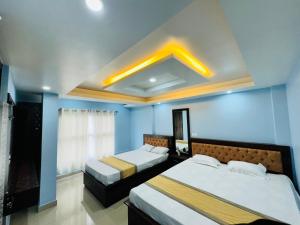 two beds in a room with blue walls at Hill inn homestay in Sukhia Pokhari