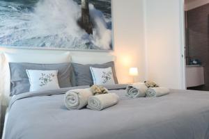 a white bed with towels and pillows on it at Casa Magenta Apartment 2 in Valeggio sul Mincio