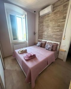a bedroom with a pink bed with two towels on it at Il Casale Appartamento Assisi in Assisi +39 photos