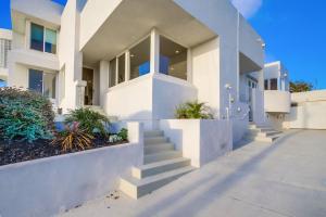 Una casa blanca con escaleras al frente. en Ultimate Getaway: Spa Game Rooms Firepit Views, en San Diego