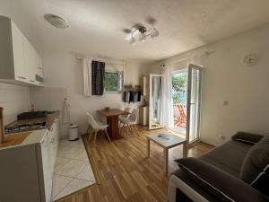 a kitchen and living room with a couch and a table at Apartments Rotim, Mljet, Sutmiholjska in Babino Polje
