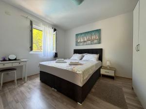 a bedroom with a large bed and a desk at Apartments Rotim, Mljet, Sutmiholjska in Babino Polje