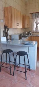 a kitchen with two stools in front of a counter at Yellowwood Accommodation in Polokwane