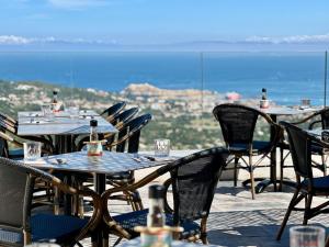 an outdoor restaurant with tables and chairs with a view at Casa Sant'Antone in Santa-Reparata-di-Balagna
