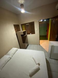 a bedroom with a white bed with a towel on it at SUITE 501 - Casa Astral - Praia da Pipa in Pipa