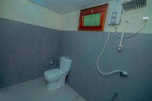 een badkamer met een toilet en een raam bij Sinharaja Hostel 114 in Deniyaya