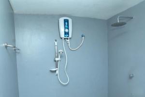 een douche in een badkamer met een telefoon aan de muur bij Sinharaja Hostel 114 in Deniyaya