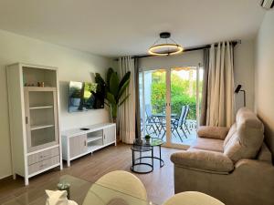 a living room with a couch and a table at Apartamentos Perseo Albir in Albir