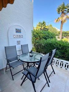 a glass table and chairs on a patio at Apartamentos Perseo Albir in Albir