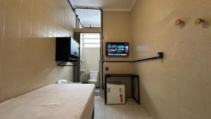 a hospital room with a bed and a television at Suíte 12 • Praia das Pitangueiras in Guarujá