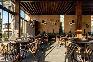 a restaurant with wooden tables and chairs and windows at Elios Hill in Hersonissos