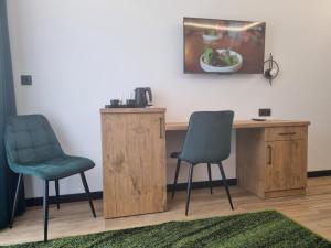 two chairs and a desk in a room with a painting at SkyHel Apartament 201 in Hel