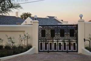 a black gate in front of a white house at Atholl Guest House in Johannesburg