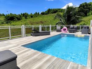una piscina con sillas y una terraza de madera en Azur, bas de villa piscine, vue mer, en La Trinité 18 fotos más
