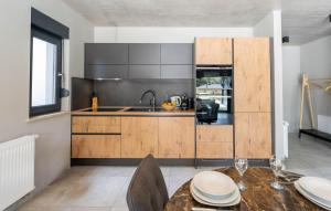una cocina con armarios de madera y una mesa con platos. en Villa Fran, en Pula
