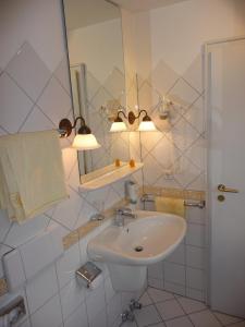 a white bathroom with a sink and a mirror at Hotel Restaurant Piärdestall Hövelhof in Hövelhof