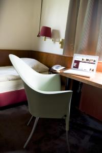 a room with a desk with a laptop and a bed at Hotel Restaurant Piärdestall Hövelhof in Hövelhof