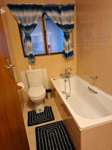 a bathroom with a toilet and a tub and a window at Eden Dunes 69 in Shelly Beach