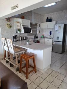 a kitchen with a white counter and a refrigerator at Eden Dunes 69 in Shelly Beach