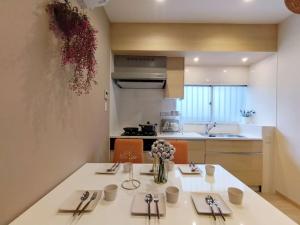 東京にある12池袋最中心 两室一厅两浴室两卫生间 池袋站7分 2 rooms Ikebukuro center 7 mins to ST Max 8P 直达新宿 涉谷 表参道 池袋 上野 代代木 银座 原宿のテーブルと椅子付きのキッチン、 +30枚の写真