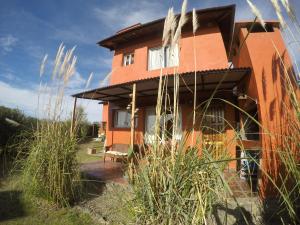 a house with a patio in front of it at Punta Piedra cabañas & suites in Los Reartes