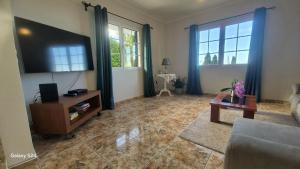 a living room with a flat screen tv and a couch at Casa Ventura in Arco da Calheta