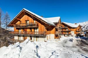 un chalet dans la neige avec un tas de neige dans l'établissement Appartement 2 Pièces 2/4 Personnes MAE-0541, aux Orres