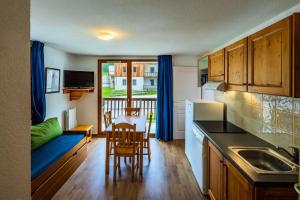 - une cuisine avec un canapé, une table et des chaises dans l'établissement Appartement 2 Pièces 2/4 Personnes MAE-0541, aux Orres